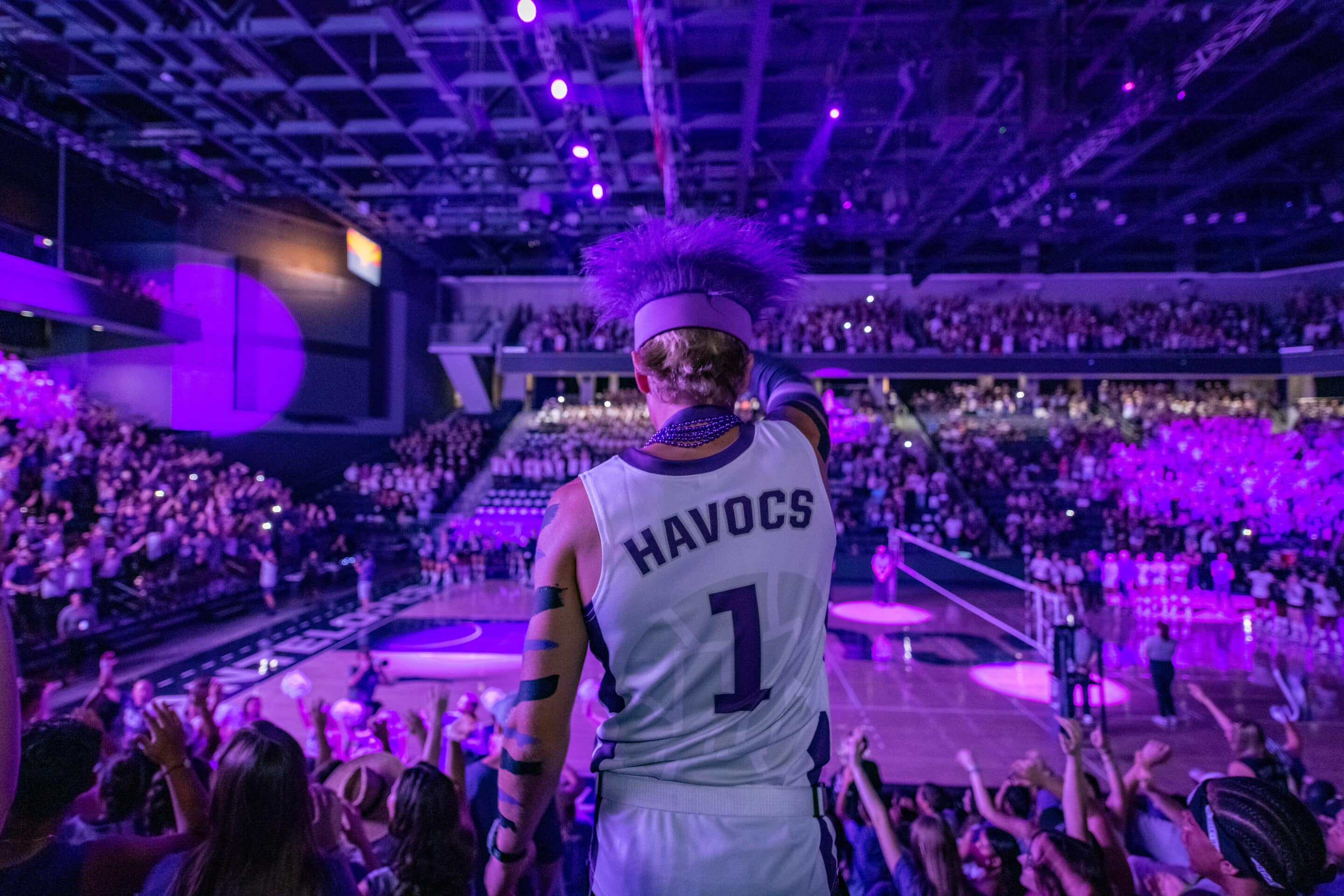 A GCU Havocs leader stands at the top of the student section with his back to the camera.