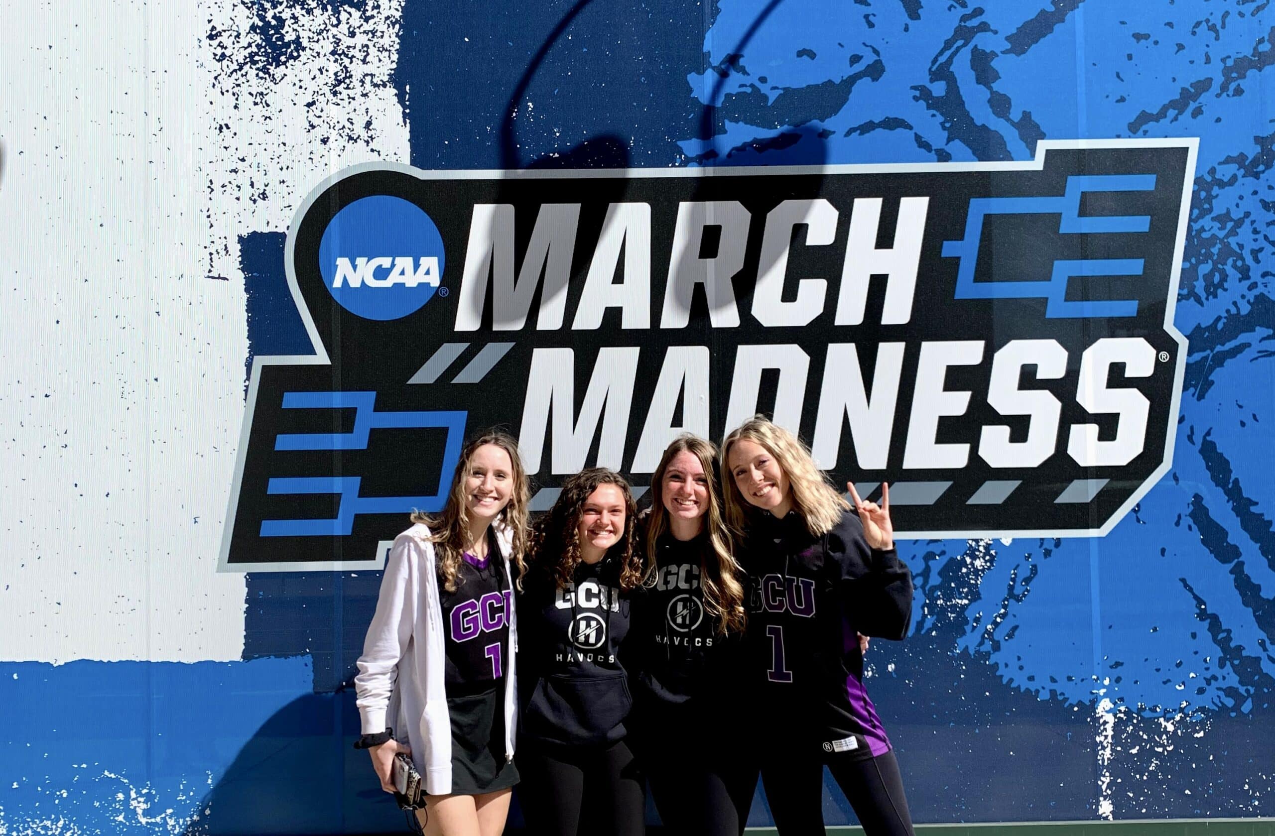 The student section leaders of Grand Canyon University stand in front of a wall that says "March Madness"