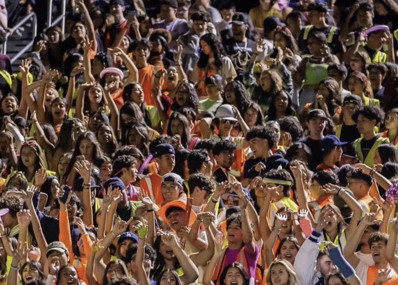 La Habra student section enjoying Neon Night with vibrant, colorful outfits, radiating energy and excitement.