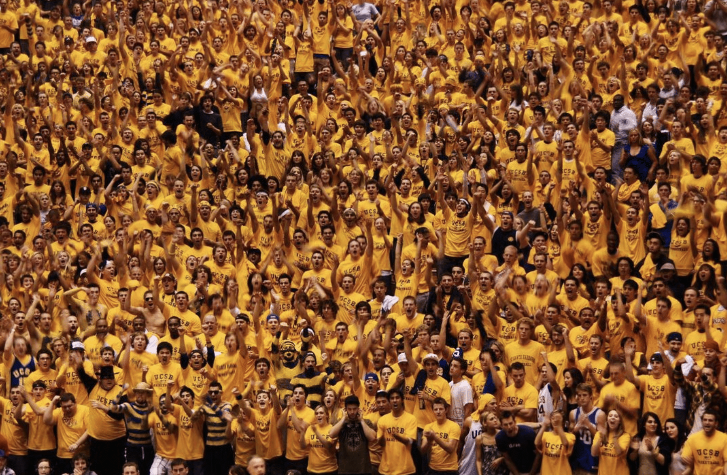The Surge student section, dressed in vibrant yellow, fills the bleachers, standing united and cheering passionately at the event.