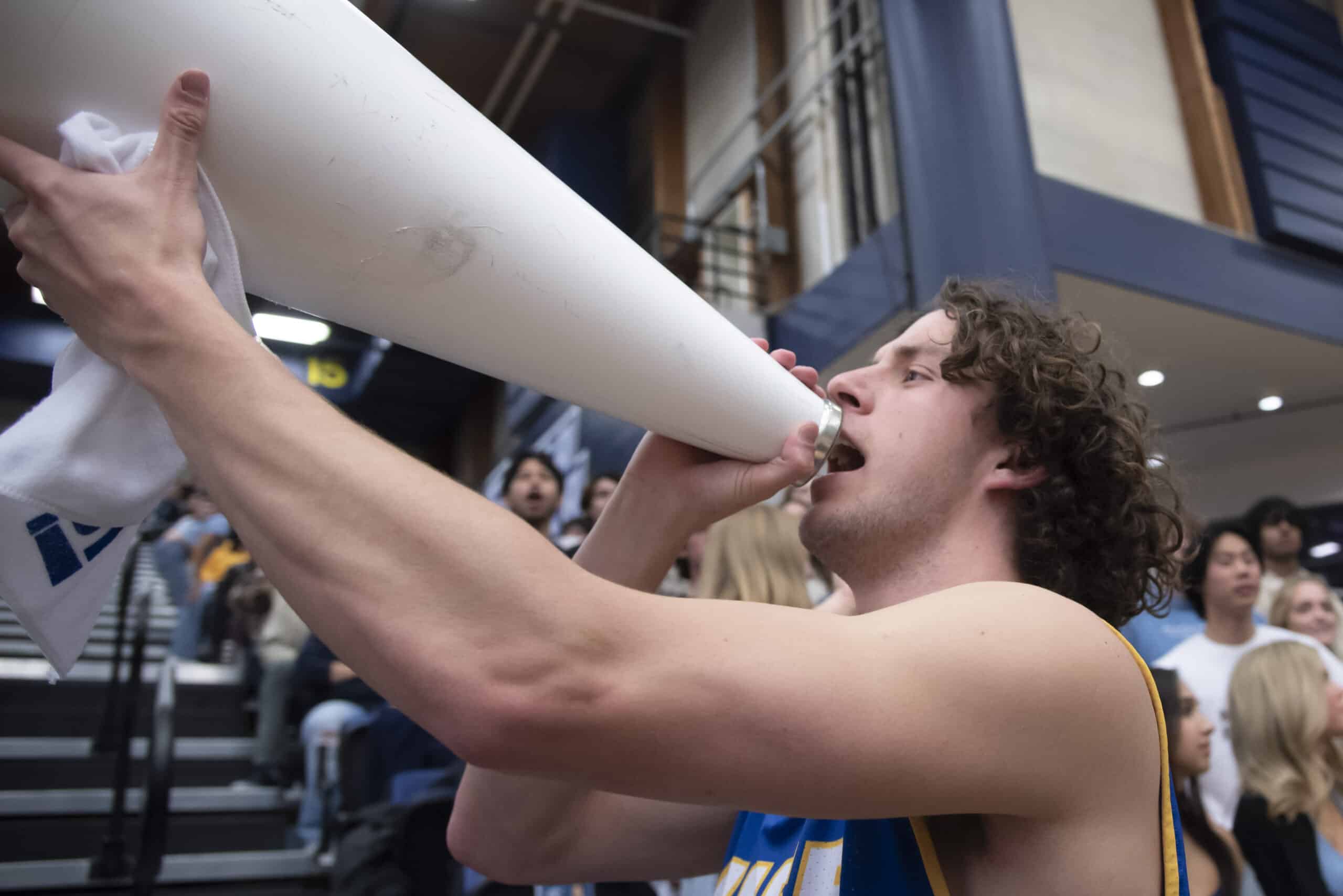 University of California Santa Barbara student section leader holding a megaphone and leading cheers.