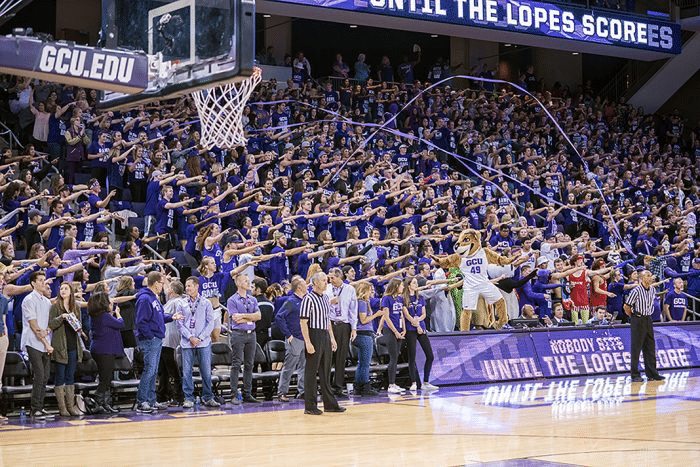 Grand Canyon University student section pointing at their opponent in sync as streamers are thrown to create an engaging fan experience.